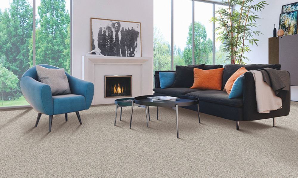 Light gray carpet in a living room with a fireplace and blue chairs