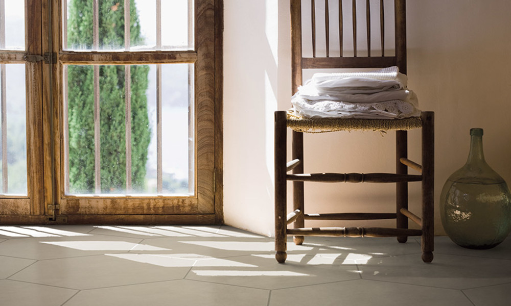 Light stone-look tile in a sunroom with a wooden chair